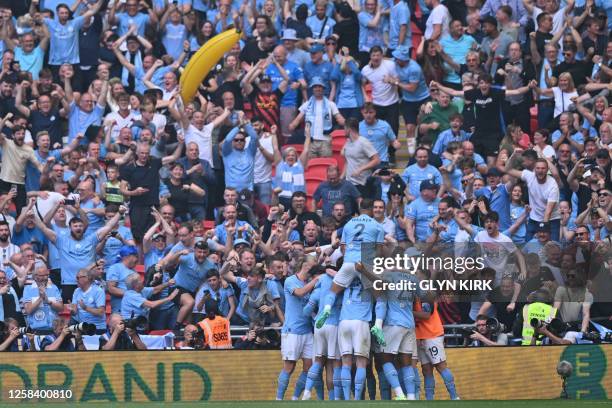 Manchester City's German midfielder Ilkay Gundogan celebrates with teammates after scoring their second goal during the English FA Cup final football...