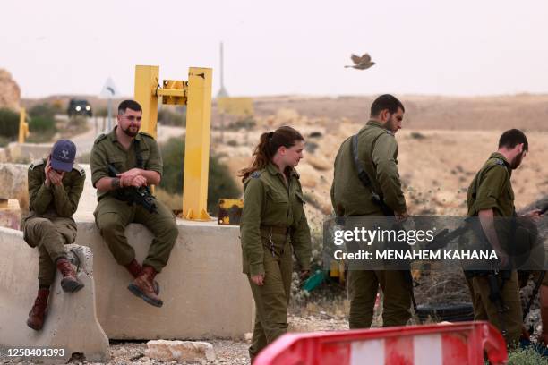 Israeli soldiers are pictured outside the Mount Harif military base near the city of Mitzpe Ramon in Israel's southern Negev desert, adjacent to the...