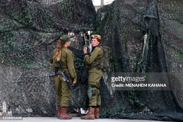 Israeli soldiers are pictured outside the Mount Harif military base near the city of Mitzpe Ramon in Israel's southern Negev desert, adjacent to the...