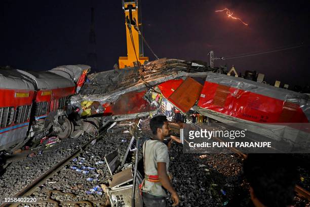 Graphic content / A rescue worker is seen near the carriage wreckage of a three-train collision near Balasore, in India's eastern state of Odisha, on...