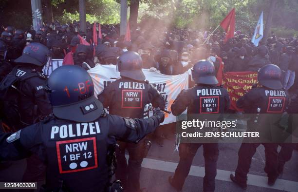 Demonstrators face policemen during a so-called "national day of action" organised by far-left activists on June 3, 2023 in Leipzig, eastern Germany,...