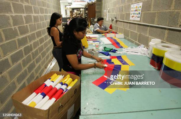 Empleadas de la empresa "La Casa de la Bandera" trabajan en banderines modificados, el 10 de marzo de 2006 en Caracas. Parlamentarios oficialistas...