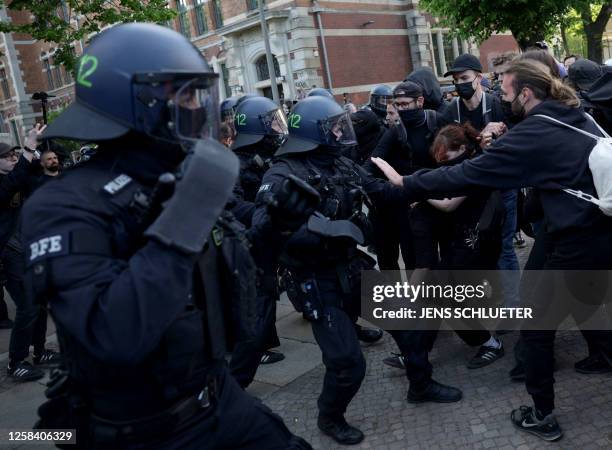 Demonstrators face policemen during a so-called "national day of action" organised by far-left activists on June 3, 2023 in Leipzig, eastern Germany,...