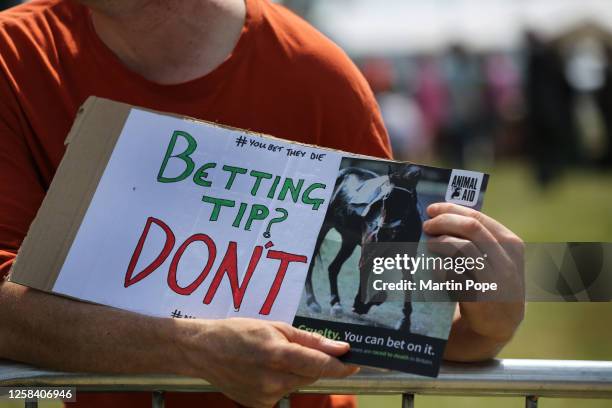 An Animal Rising supporter holds a sign saying 'Betting Tip? - Don't' on June 3, 2023 in Epsom, England. Protesters from Animal Rising want to...