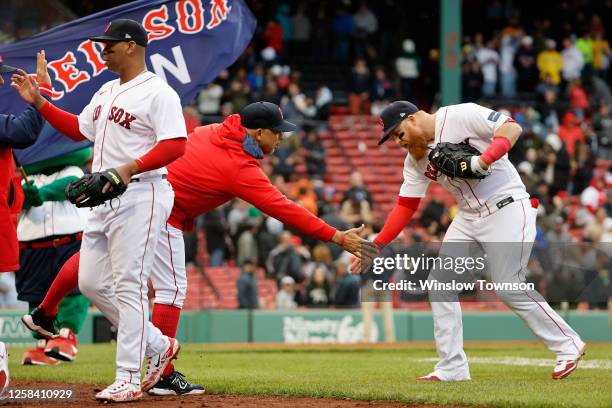 Manager Alex Cora of the Boston Red Sox congratulates Justin Turner after their 8-5 win over the Tampa Bay Rays in game one of a doubleheader at...