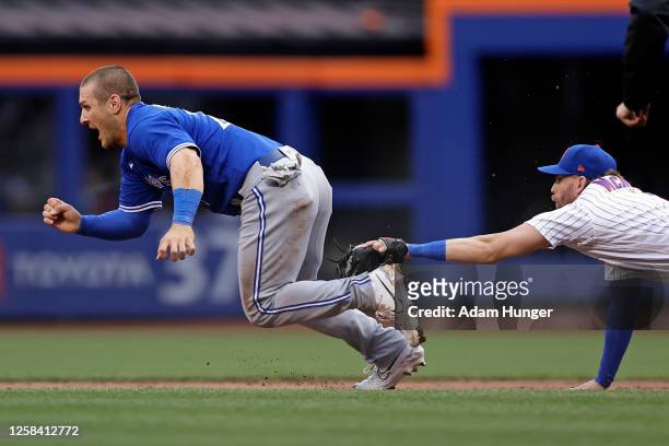Daulton Varsho of the Toronto Blue Jays is tagged out trying to steal second base by Jeff McNeil of the New York Mets during the second inning at...