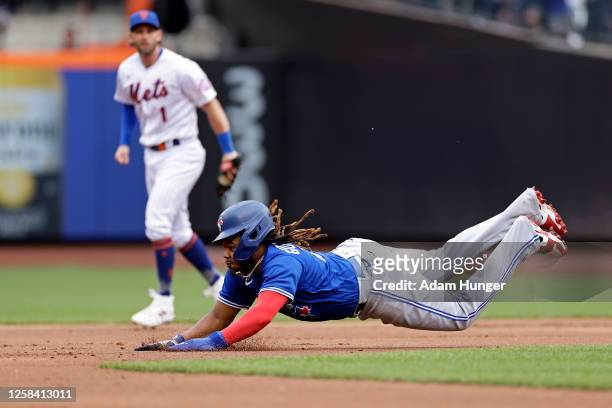 Vladimir Guerrero Jr. #27 of the Toronto Blue Jays steals second base in front of Jeff McNeil of the New York Mets during the first inning at Citi...