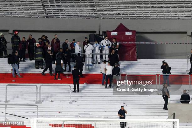 Police officers work in the perimeter where a fan died after falling down from the stands following the suspension of River Plate and of Defensa y...