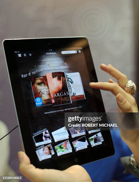 Fair goer tries out the textunes eBook reader app on an Apple iPad at the Leipzig Book Fair on March 15, 2012 on the fairgrounds in Leipzig, eastern...