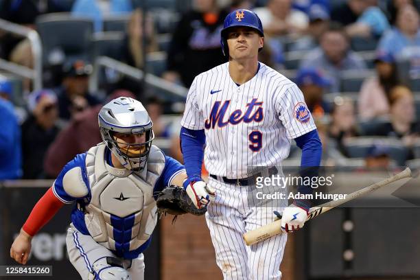 Brandon Nimmo of the New York Mets reacts as he is tagged by Alejandro Kirk of the Toronto Blue Jays after striking out to end the ninth inning at...