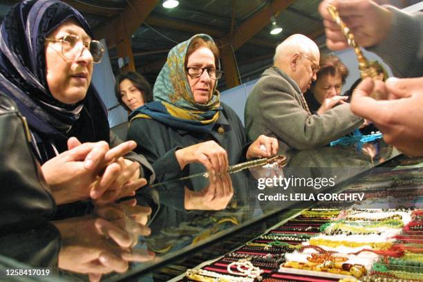 An Iranian vendor displays prayer beads made out of the tiger eye stone 14 February 2002 at the sixth exhibition of Iranian goods in Amman. There was...