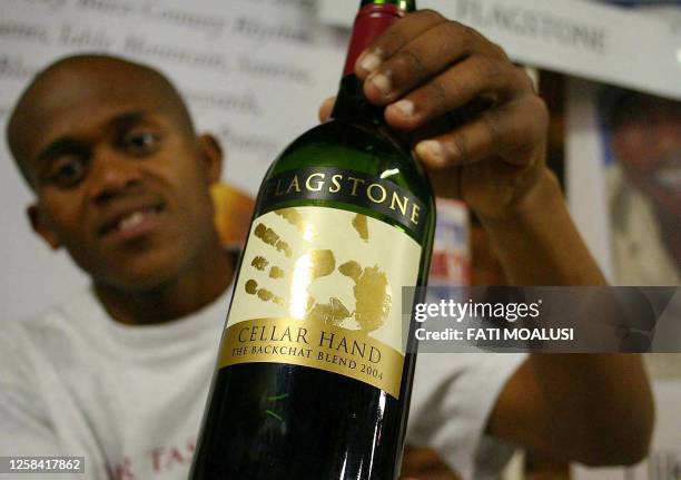 South African Gerald Cakijana shows his hand print on a wine label at the Soweto wine festival in South Africa 02 September 2005. He travelled to...