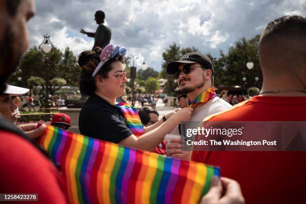 Sydney Saenz of Seattle, left, ties a rainbow handkerchief on Daniel Bonaccorso, also of Seattle at Disney World's Magic Kingdom on Saturday, June 3,...