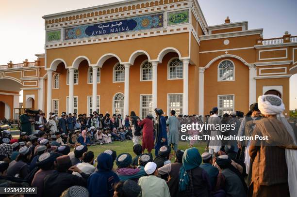 Men and boys watch others wrestle in the evening in the Aino Mina neighbourhood of Kandahar city, in southern Afghanistan, on May 25, 2023 .