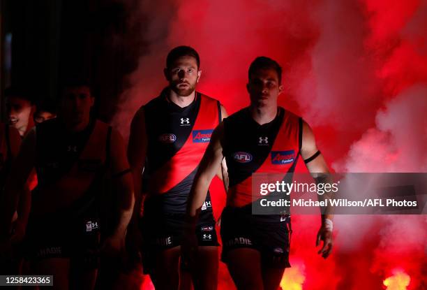 Jayden Laverde and Zach Merrett of the Bombers walk up the race during the 2023 AFL Round 12 match between the Essendon Bombers and the North...