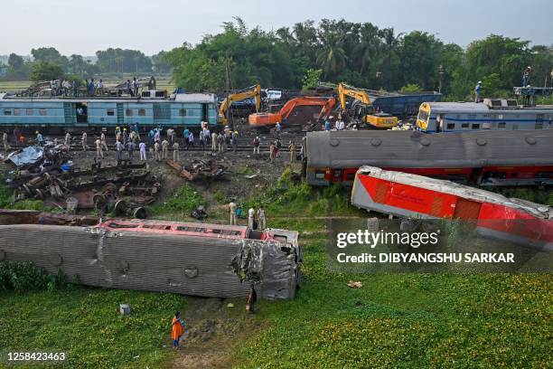 Graphic content / TOPSHOT - Policemen inspect the wrecked carriages of a three-train collision near Balasore, in India's eastern state of Odisha, on...