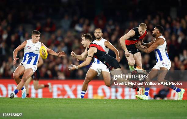Zach Merrett of the Bombers handpasses the ball during the 2023 AFL Round 12 match between the Essendon Bombers and the North Melbourne Kangaroos at...