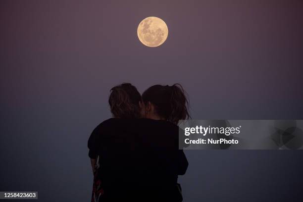 Couples watching the full moon on the night of this Saturday day June 3 at Mole Beach in Florianopolis Brazil