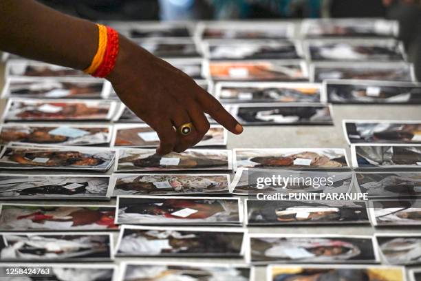 Graphic content / TOPSHOT - A victim's family member looks at photographs to identify the body at a business park used as temporary mortuary for the...