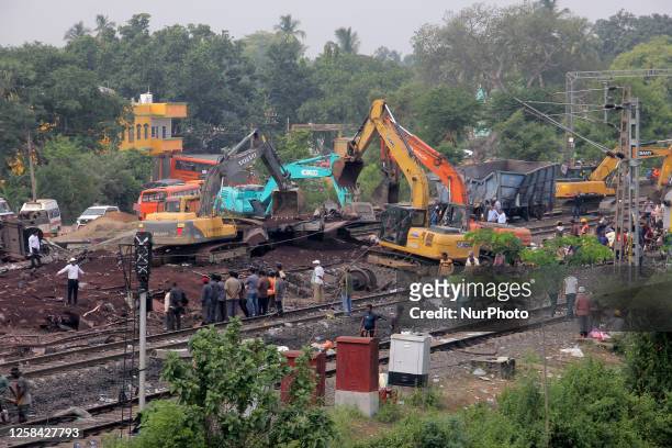 Railway workers and NDRF people are seen at the Coromandel express train accident site as they are busy in the derailed coaches removing work and...