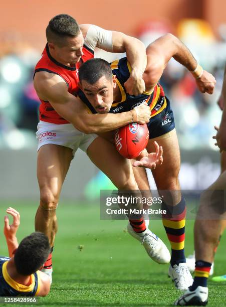 David Zaharakis of the Bombers tackles Taylor Walker of the Crows during the round 8 AFL match between the Adelaide Crows and the Essendon Bombers at...