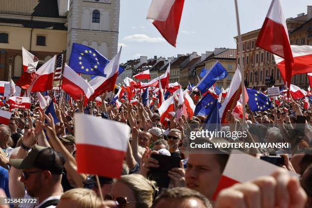 People wave the European and Polish flag during a rally during an anti-government demonstration organized by the opposition in Warsaw on June 4,...