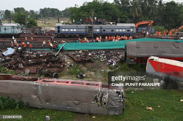 Railway workers help to restore services at the accident site of a three-train collision near Balasore, about 200 km from the state capital...