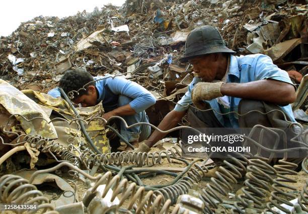 Two scavengers select scrap iron imported from European countries, at Tanjung Priok port in Jakarta 17 September, 2002. Steelmakers in Indonesia...