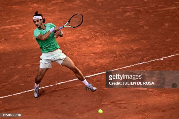 Italy's Lorenzo Musetti plays a forehand return to Spain's Carlos Alcaraz Garfia during their men's singles match on day eight of the Roland-Garros...