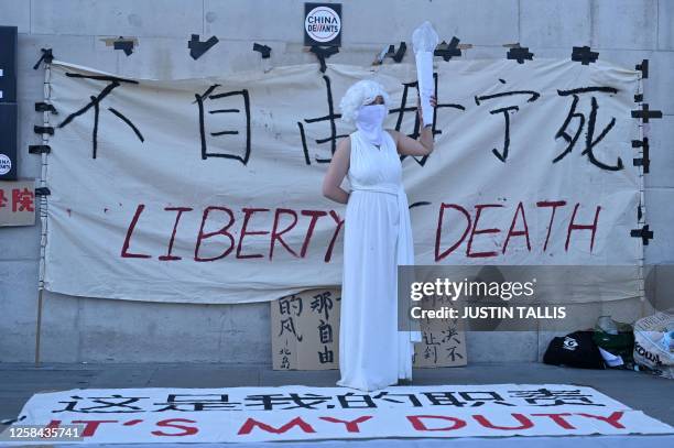 Protesters stage a reenactment of the Tiananmen Square incident in Trafalgar Square in London on June 4 on the 34th anniversary of the 1989 crackdown...