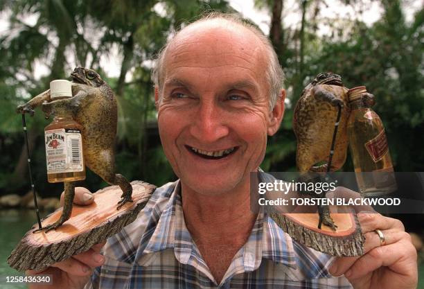 John Kreuger displays two of his stuffed cane toads in Townsville, 22 July 2001, which are extremely popular with foreign tourists to the sunshine...