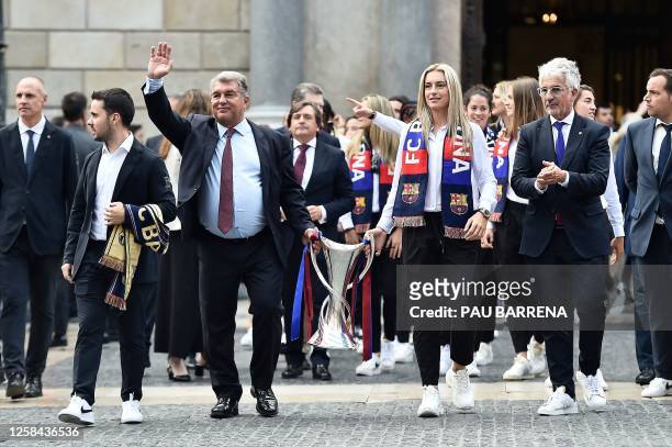 Barcelona's President Joan Laporta and Barcelona's Spanish midfielder Alexia Putellas carry the trophy to the Generalitat Palace, housing the Catalan...