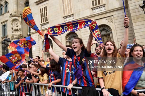 Supporters cheer as FC Barcelona's players celebrate with their trophy in Barcelona, on June 4, 2023 one day after winning the UEFA Women's Champions...