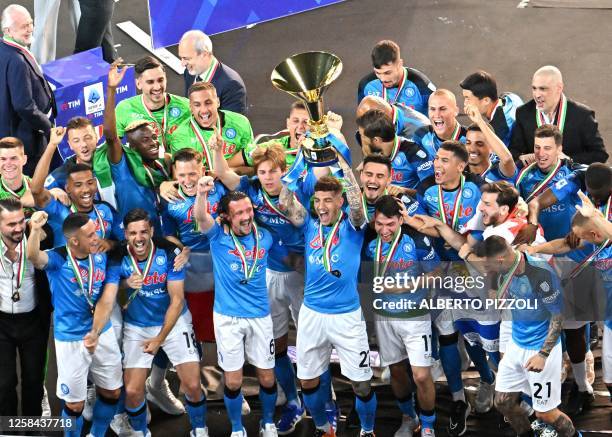 Napoli's Italian defender Giovanni Di Lorenzo , holding the Italian Scudetto Championship trophy, and his teammates celebrate winning the 2023...