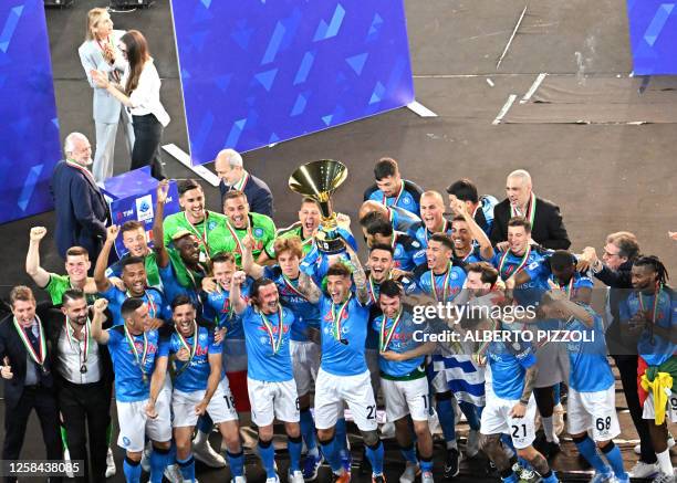 Napoli's Italian defender Giovanni Di Lorenzo holds the Italian Scudetto Championship trophy as he and his teammates celebrate winning the 2023...