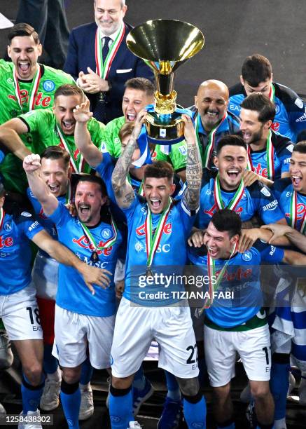 Napoli's Italian defender Giovanni Di Lorenzo holds the Italian Scudetto Championship trophy as he and his teammates celebrate winning the 2023...