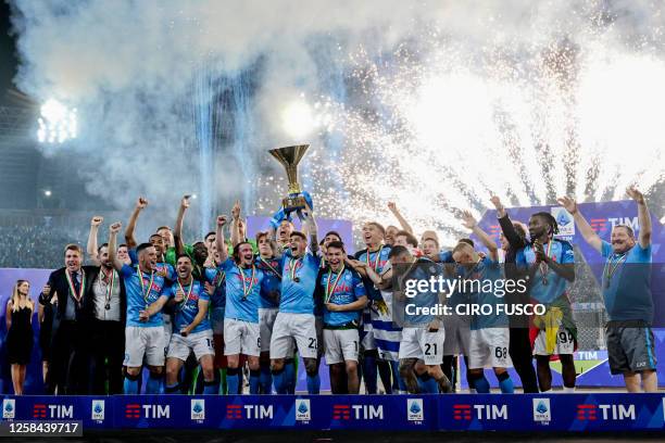 Napoli's Italian defender Giovanni Di Lorenzo , holding the Italian Scudetto Championship trophy, and teammates celebrate winning the 2023 Scudetto...