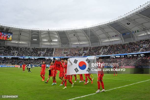 South Korea's players display their national flag as they celebrate after defeating Nigeria 1-0 in extra-time of the Argentina 2023 U-20 World Cup...