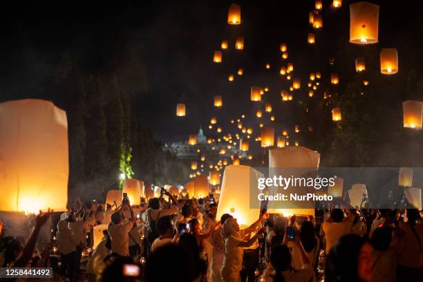 Buddhist devootes and tourist release lanterns into the air as a symbol of enlightening and peace during Vesak Day celebration at Borobudur temple,...