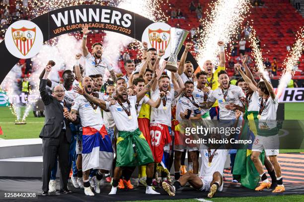 Ivan Rakitic and Jesus Navas of Sevilla FC lift the trophy as they celebrates with teammates during the award ceremony following the UEFA Europa...