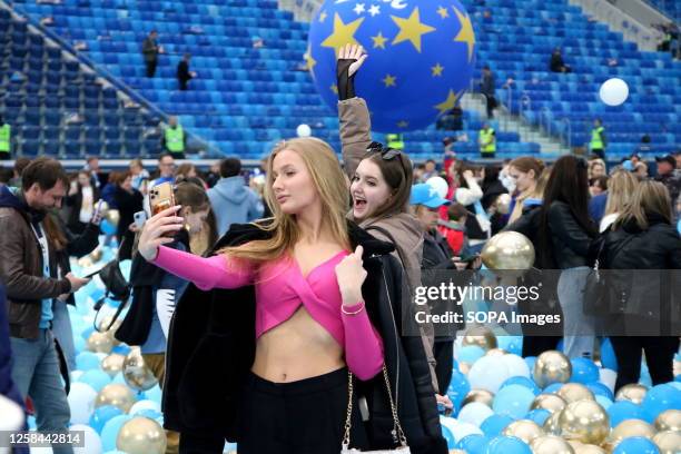 Young girls are happy and pose on the football field surrounded by balloons. Zenit football club celebrated the end of the championship season in an...