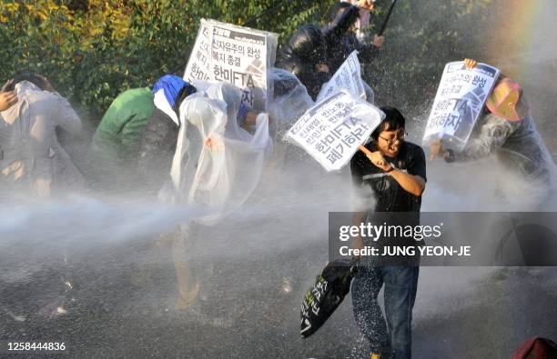 South Korean police use a water cannon to disperse demonstrators during a rally opposing a free trade agreement with the United States outside the...