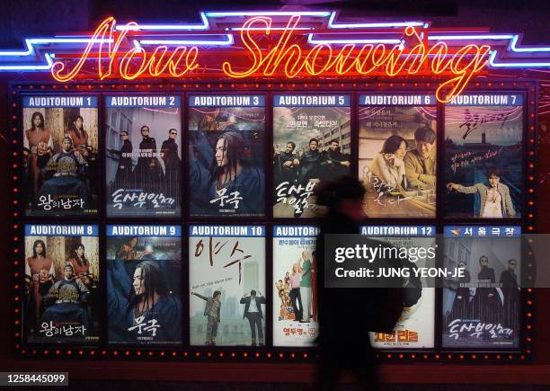 South Korean walks in front of movie posters at a cinema in downtown Seoul, 26 January 2006. South Korea said it would reduce by half its screen...