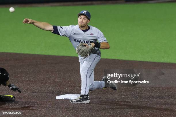 Xavier infielder Jack Housinger makes a throw to turn a double play during the Nashville Regional championship game between Oregon and Xavier, June...