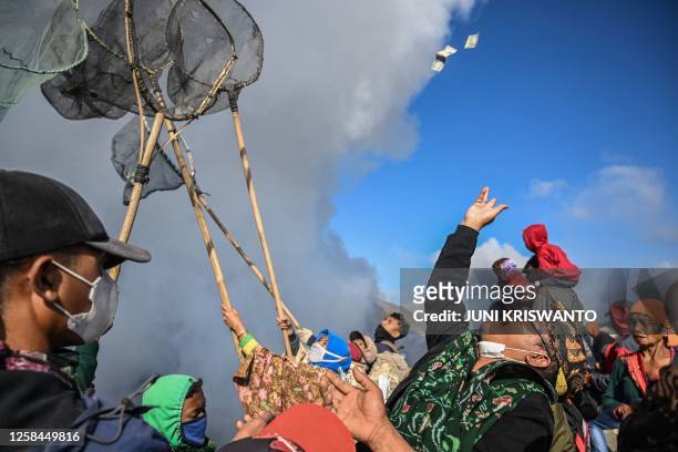 Members of the Tengger sub-ethnic group gather to present offerings at the crater's edge of the active Mount Bromo volcano as part of the Yadnya...