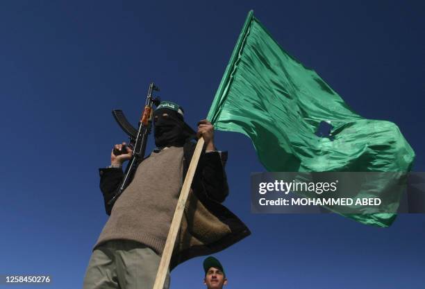 Hamas militant waves his party's flag as he celebrates the radical Islamist movement's historic victory in the second ever general election, 26...