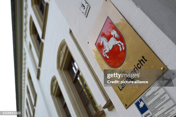 June 2023, Lower Saxony, Aurich: A sign with the Lower Saxony state coat of arms hangs at the entrance to the Aurich District Court, where a trial...