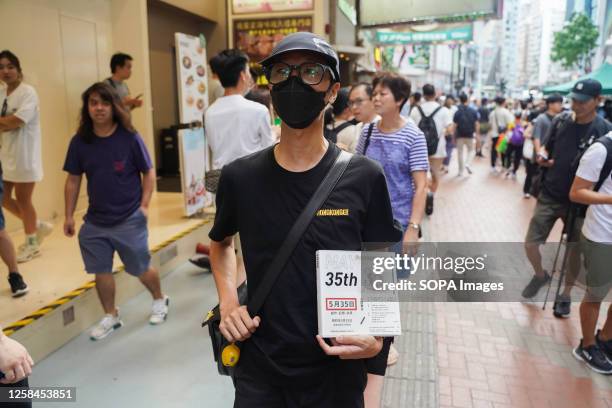 Man holds a book about the Tiananmen Square crackdown and walks on the street. June 4th is the 34th anniversary of the 1989 Tiananmen Square protests...