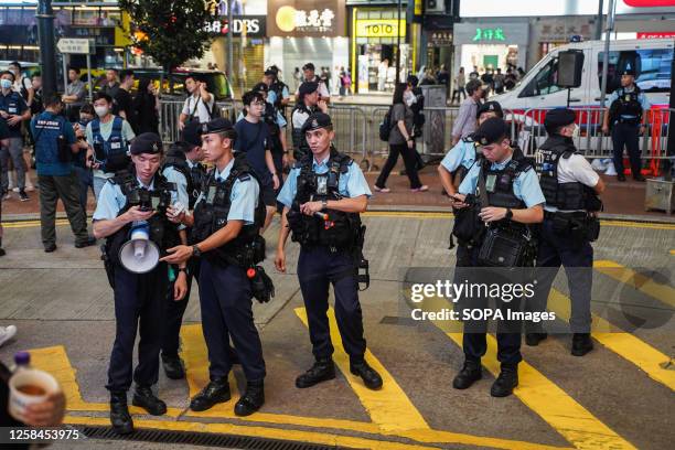 Police officers stand on the street at Causeway Bay in Hong Kong during the 34th anniversary of the 1989 Beijing's Tiananmen Square protests and...