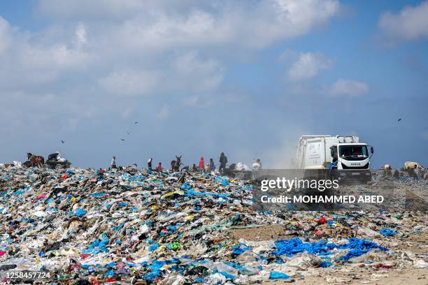 Palestinians collect plastic from a waste dump to sell to a recycling company in Beit Lahia in the northern Gaza Strip, on June 5, 2023.